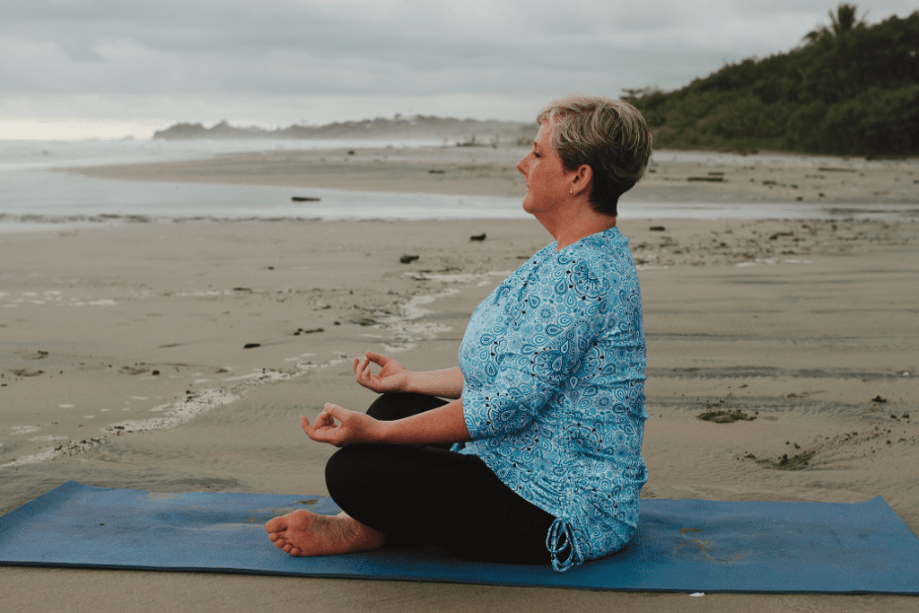 Author Cynthia Ross Tustin doing yoga at Baker's Beach in Nosara, Costa Rica, my retirement happy place