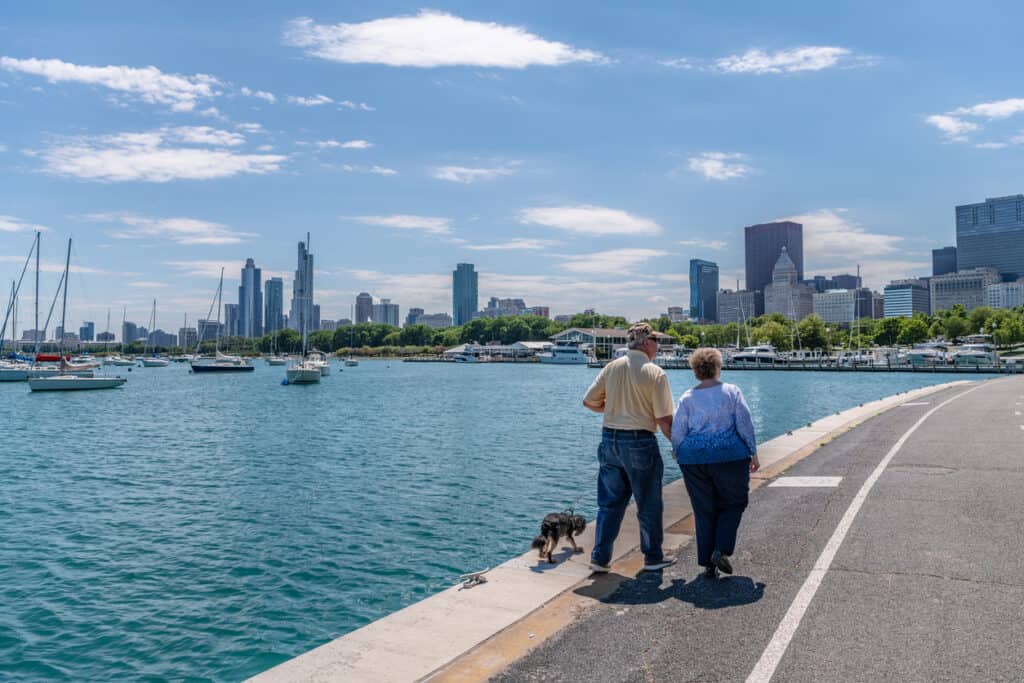 active retired couple walking their dog along the Chicago waterfront.