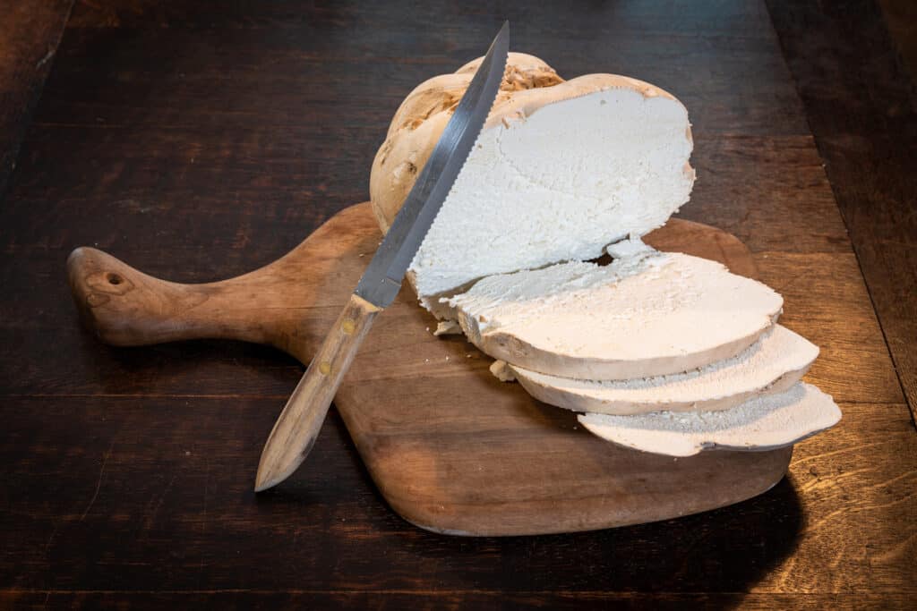 wild edible food: giant puffball sliced on a wood cutting board
