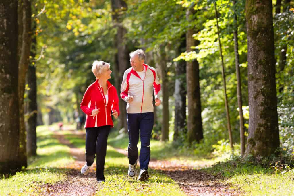 Retired couple, jogging a forested trail