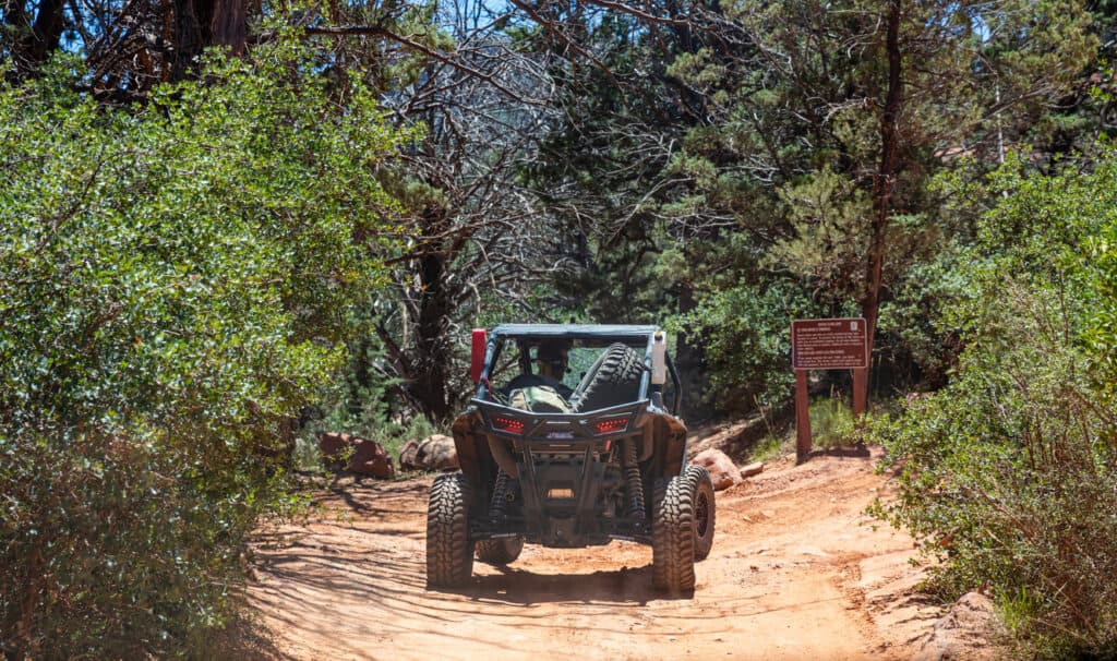 going offroad in an ATV as part of a 
sedona tour for seniors. Sedona Arizona USA. May 25, 2019. atv off road on red orange rocks, green trees background