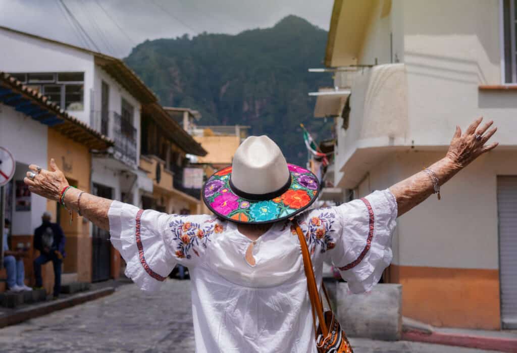 Latina woman opening her arms, enjoying the freedom from the fear of traveling alone