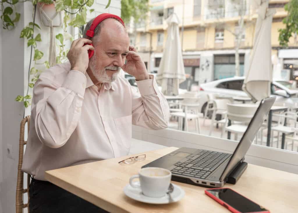 older man using technology, it can help you overcome your fear of traveling alone