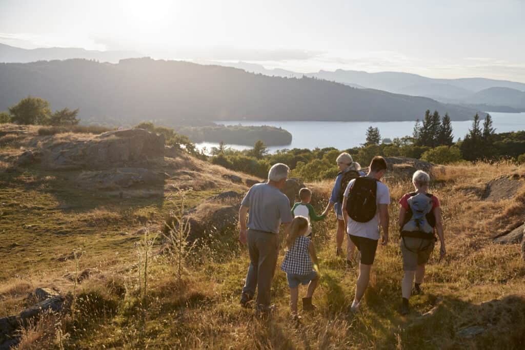 Vacationing with grandparents has multigenerational benefits for this family out hiking through Countryside In Lake District UK