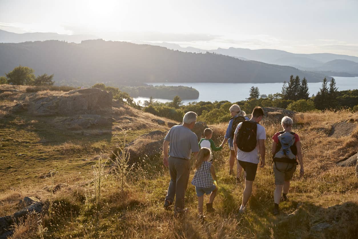 Vacationing with grandparents has multigenerational benefits for this family out hiking through Countryside In Lake District UK