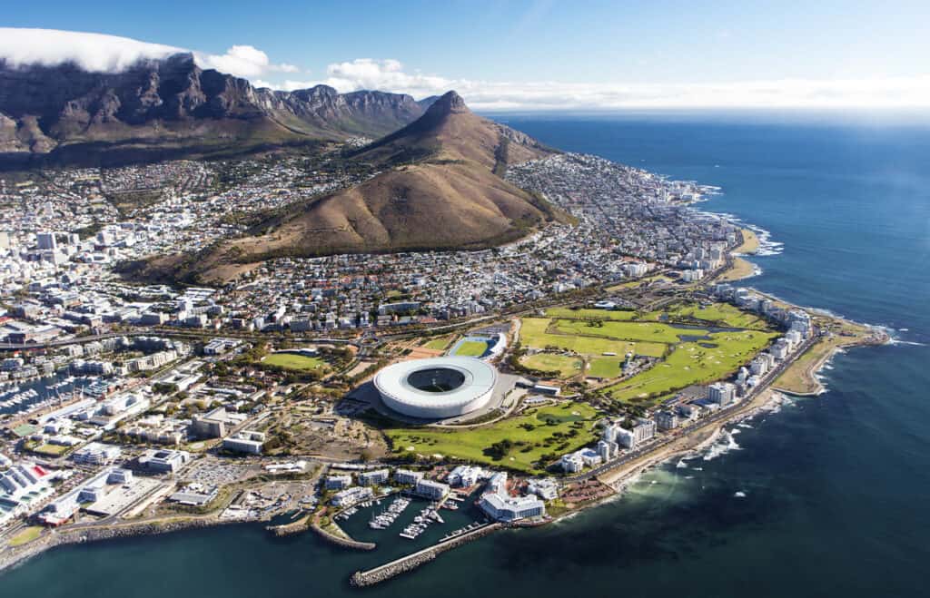 Overall aerial view of Cape Town, South Africa from helicopter with a view on Table Mountain and stadium. The diversity of this country make it ideal for cultural immersion experiences.