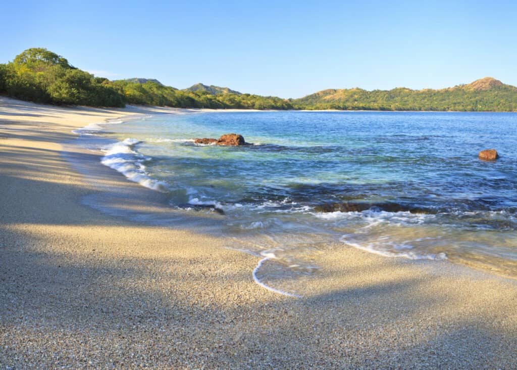 Sand and shells on Playa Conchal and the azure waters of the Pacific Ocean in Guanacaste, Costa Rica.