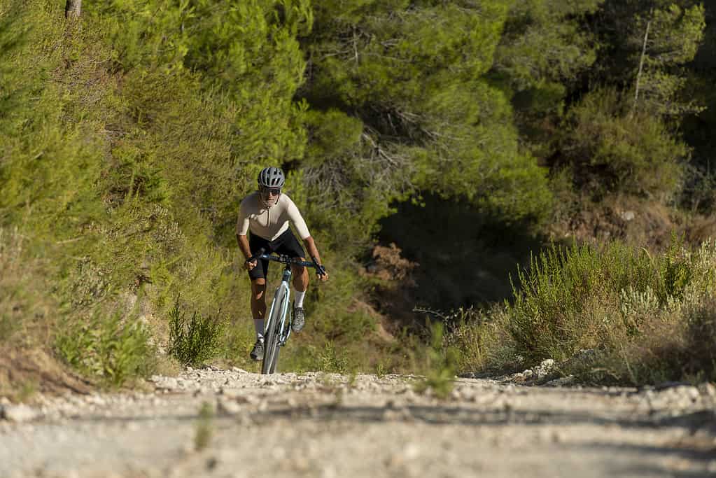 A retired male cyclist in a mediterranean forest gravel road bicycle ride in the Costa Blanca, Alicante, Spain