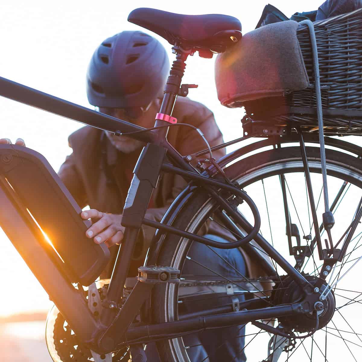 biker inserting electric bike battery: cycling on any bike is an excellent hobby for retired men and women