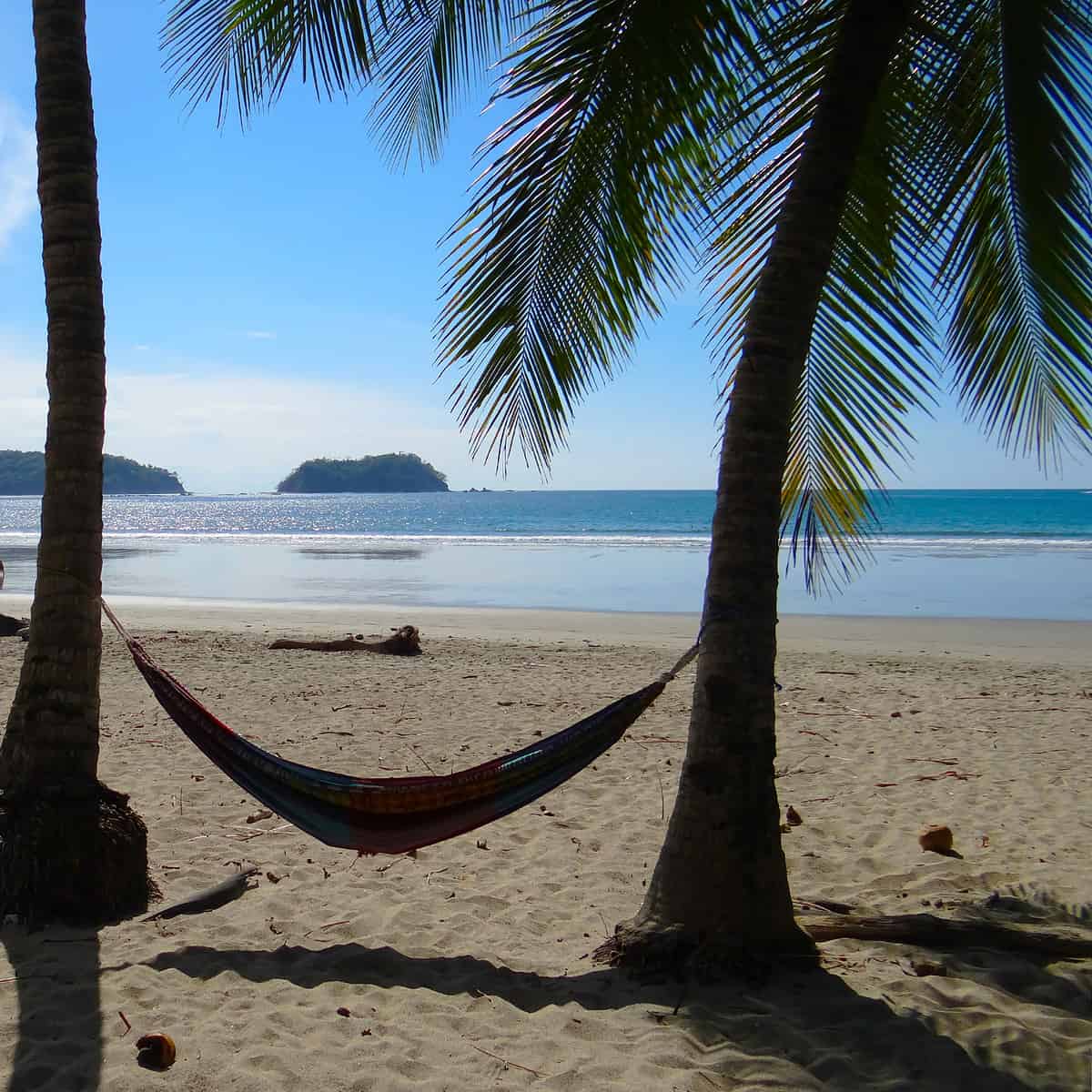 Colorful hammock in the amazing beach of Samara, Costa and view Chora Island on the horizon