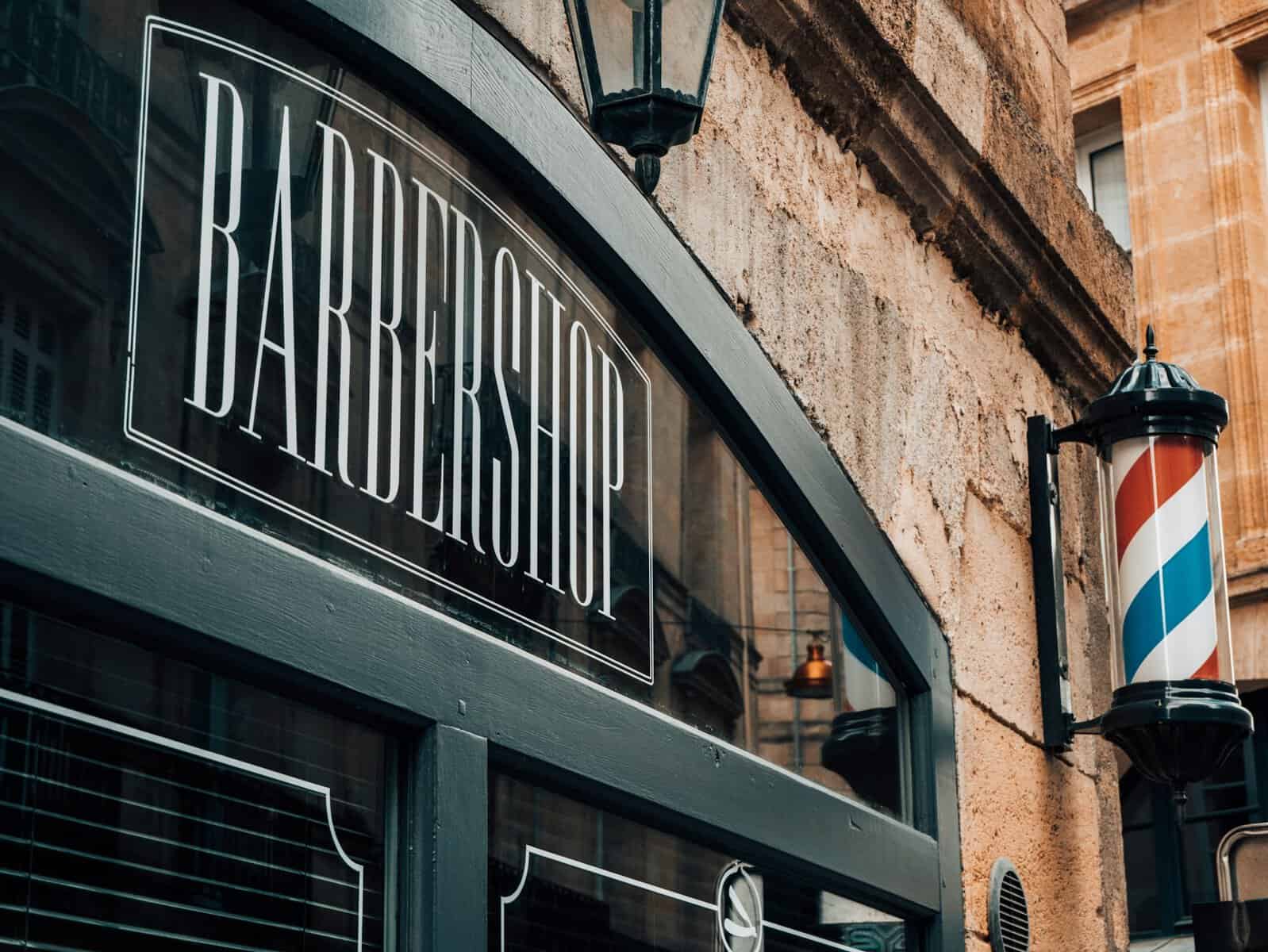 picture of a barber shop sign and a barber shop pole; retirement feels real essay